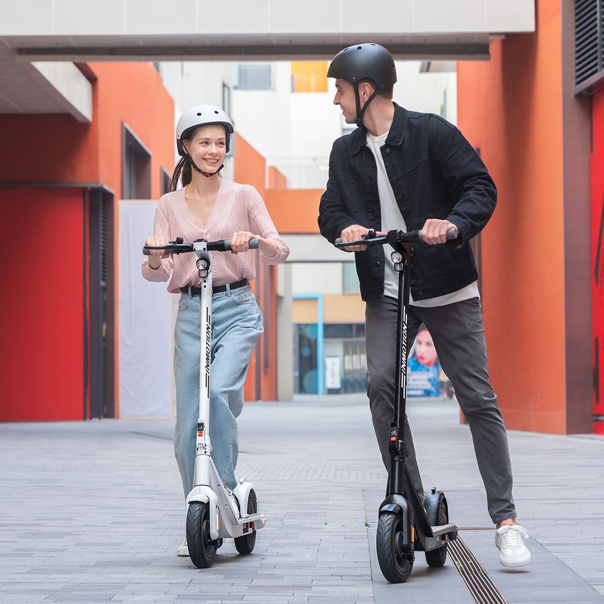 Couple enjoying INMOTION Air Pro scooters in a colorful street