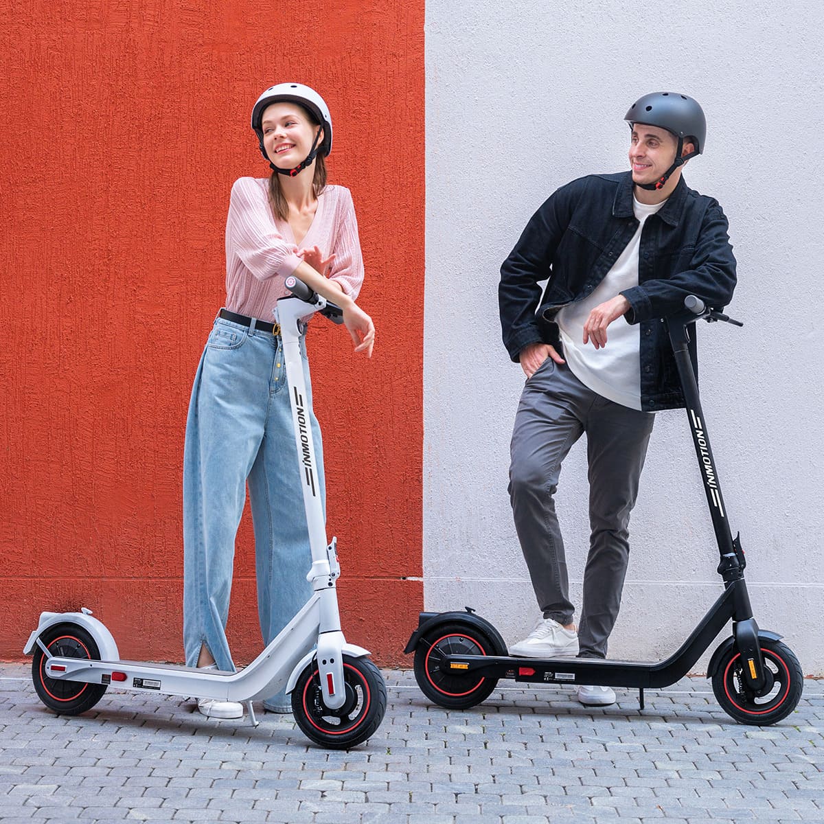 Stylish couple posed with INMOTION Air Pro electric scooters in urban setting.