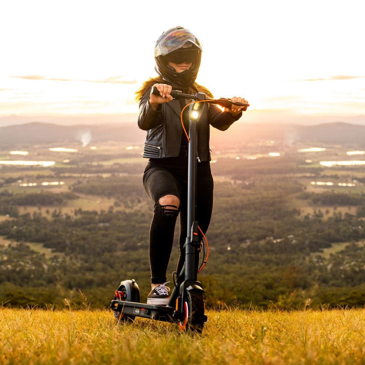 Rider on INMOTION Climber scooter against sunset, highlighting outdoor adventure.