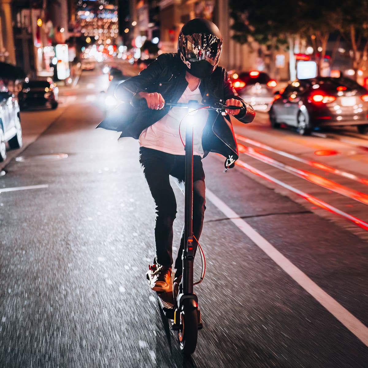 Rider on INMOTION Climber scooter at night with bright lights in urban setting.