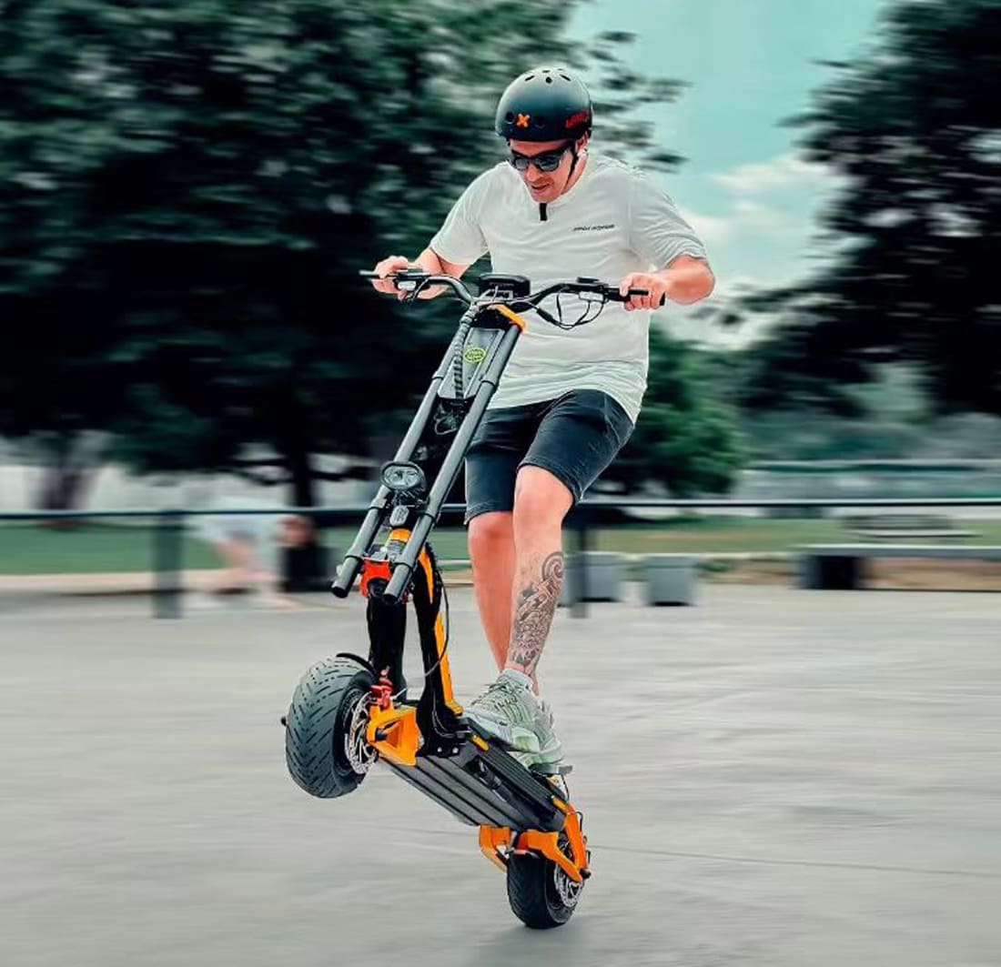 Rider performing a stunt on INMOTION RS scooter in urban environment.