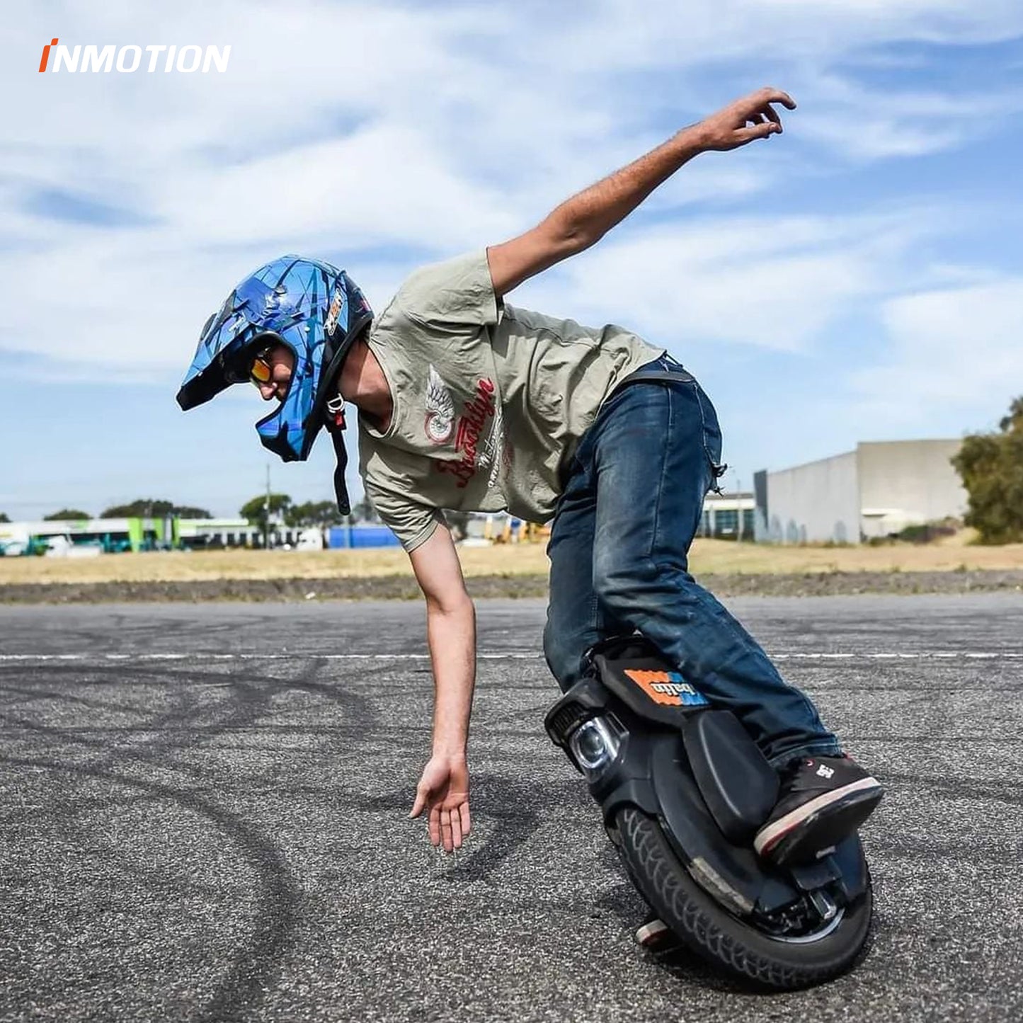 Rider performing a trick on INMOTION V11 unicycle wearing helmet and protective gear.