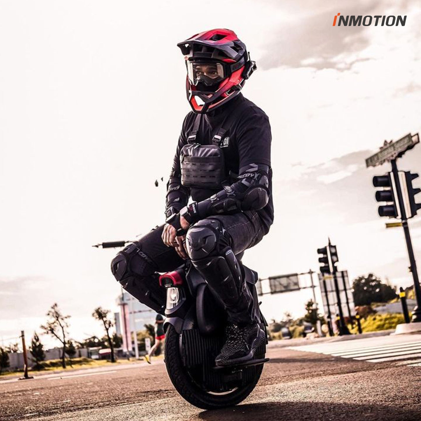 Rider wearing safety gear on INMOTION V11 at a street crossing